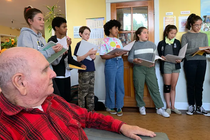 A group of visiting singers performing for residents