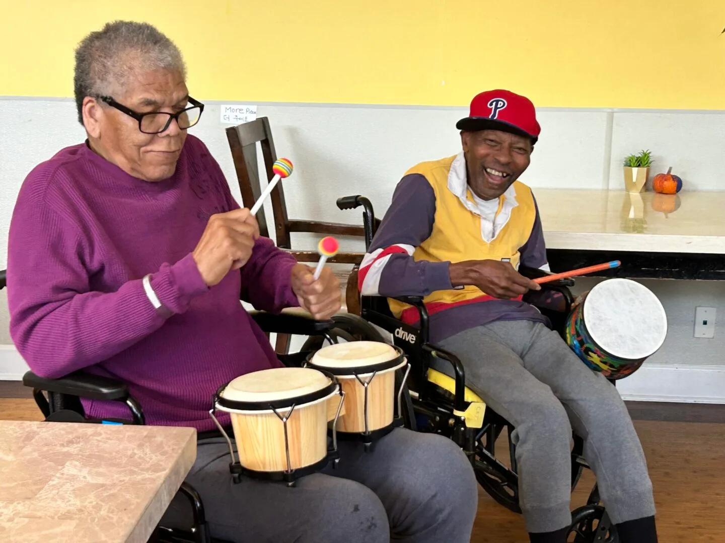 Two residents sharing a drumming activity at Dimond Care