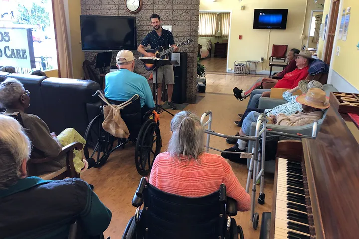 Residents listening to an entertainer in the living room