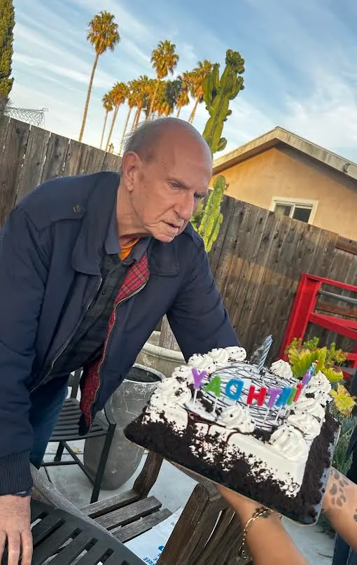 A resident celebrating a birthday outside with a cake